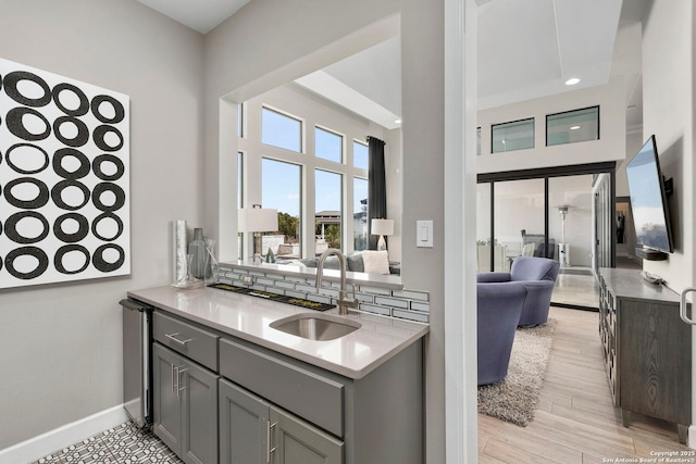 kitchen featuring light wood-type flooring, gray cabinets, and sink