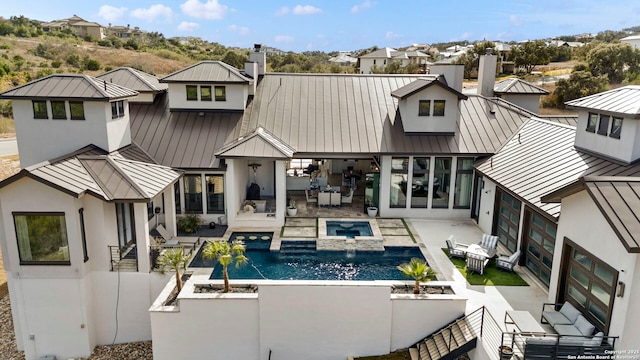 rear view of house with a pool with hot tub and a patio area