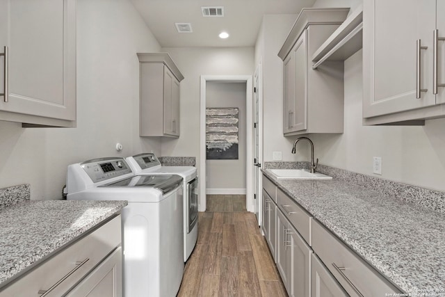 laundry room featuring cabinets, sink, and washing machine and dryer