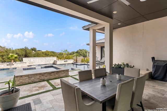 view of patio / terrace with ceiling fan, pool water feature, and a pool with hot tub