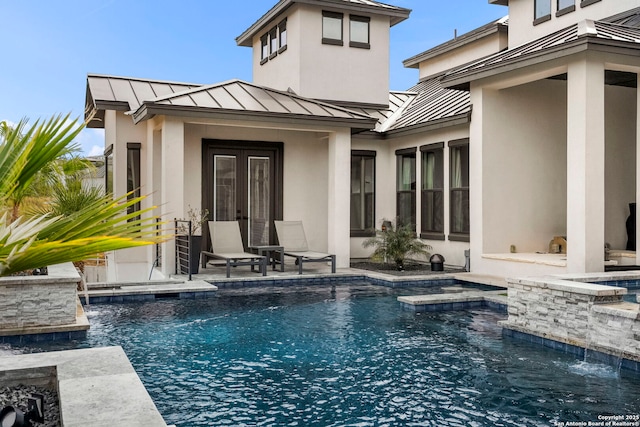 back of property featuring pool water feature, a patio area, and a pool with hot tub