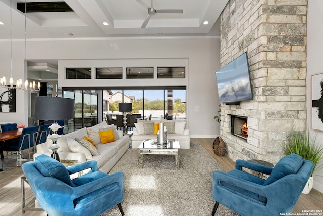 living room with ceiling fan, light hardwood / wood-style flooring, ornamental molding, and a fireplace