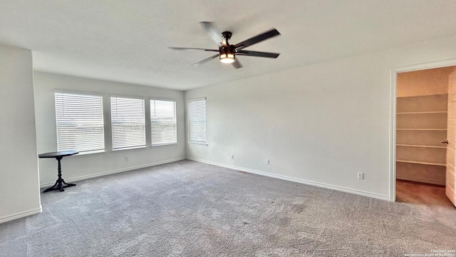 empty room with ceiling fan and carpet