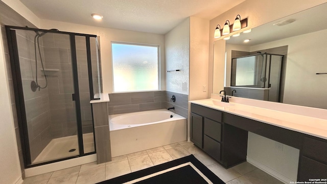 bathroom featuring vanity, tile patterned flooring, independent shower and bath, and a textured ceiling