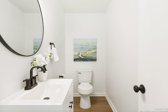 bathroom featuring toilet, hardwood / wood-style flooring, and sink