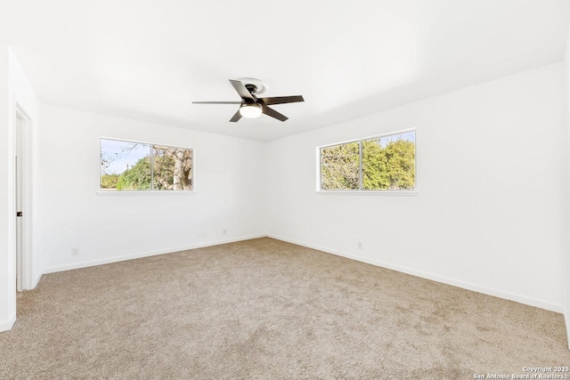 unfurnished room with ceiling fan, plenty of natural light, and light carpet