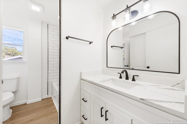 full bathroom featuring hardwood / wood-style flooring, washtub / shower combination, toilet, and vanity