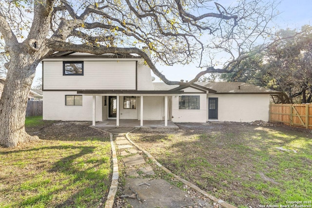 rear view of house featuring a patio area and a lawn