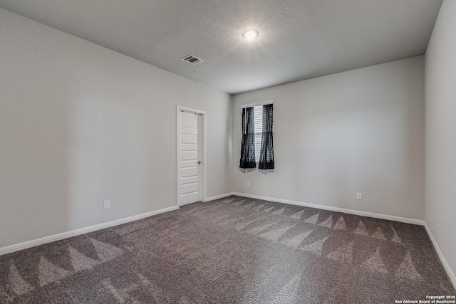 carpeted empty room featuring a textured ceiling