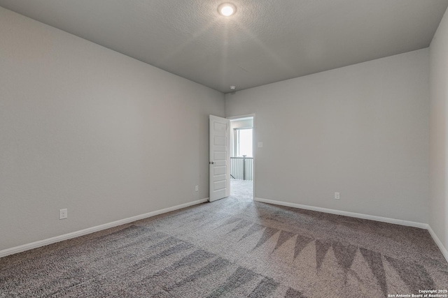 carpeted empty room featuring a textured ceiling