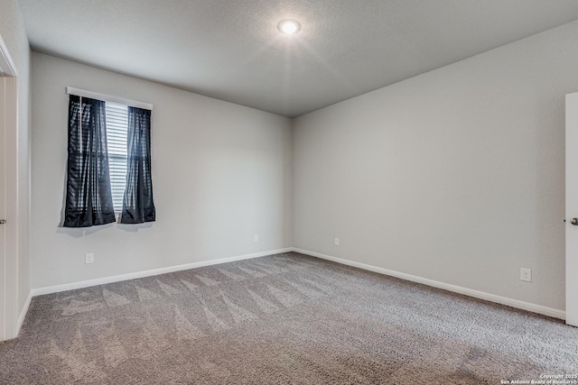 unfurnished room featuring carpet and a textured ceiling