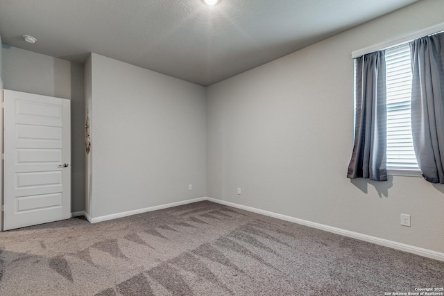 carpeted empty room with a wealth of natural light and a textured ceiling