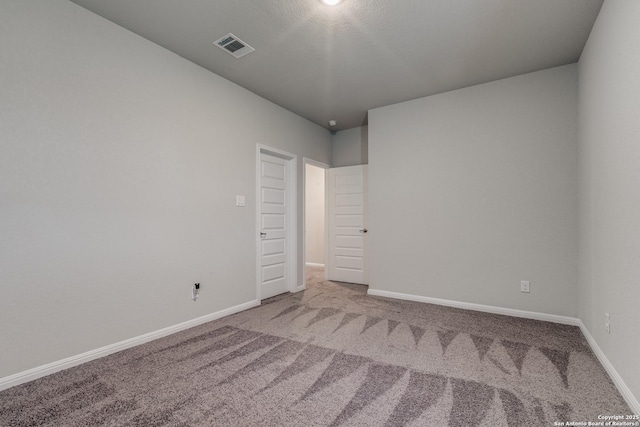 spare room with a textured ceiling and carpet flooring