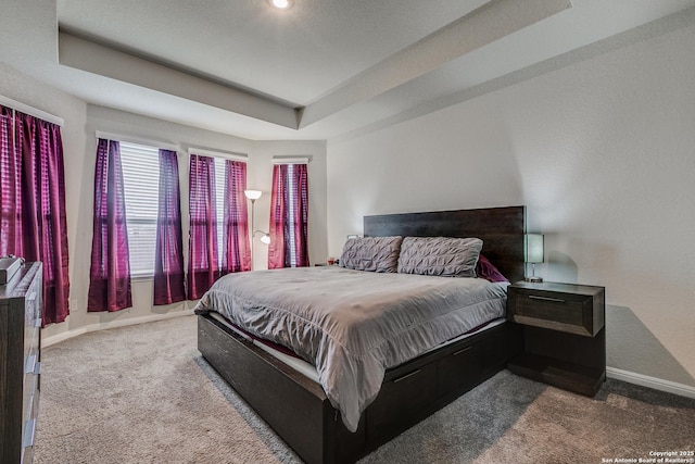 carpeted bedroom featuring a tray ceiling