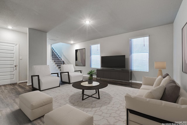 living room with a textured ceiling and hardwood / wood-style floors