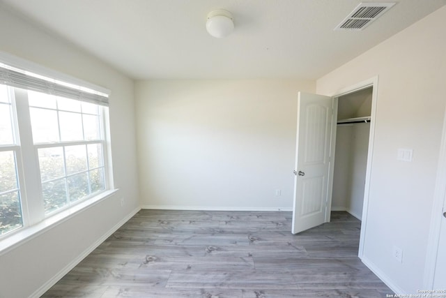 unfurnished bedroom with a closet and light hardwood / wood-style flooring