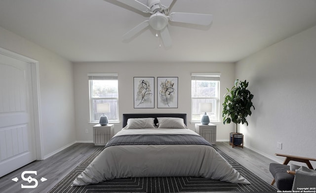 bedroom featuring ceiling fan, light hardwood / wood-style floors, and multiple windows