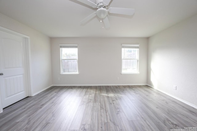 unfurnished room featuring ceiling fan, light hardwood / wood-style flooring, and a healthy amount of sunlight