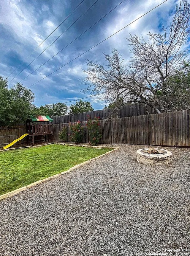 view of yard with a playground and a fire pit