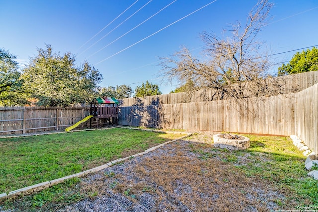 view of yard with a playground and an outdoor fire pit