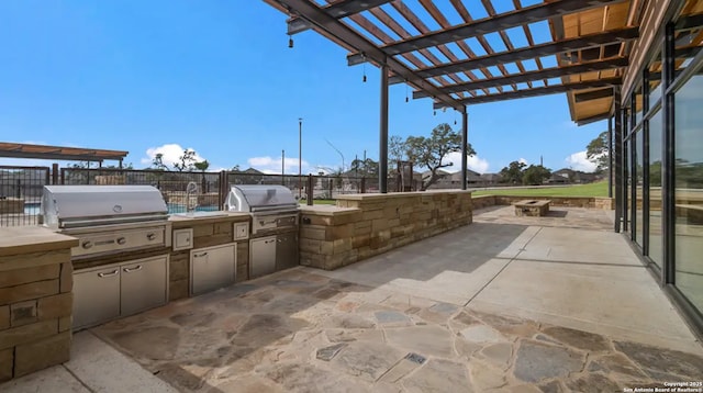 view of patio featuring an outdoor fire pit, exterior kitchen, a pergola, and grilling area