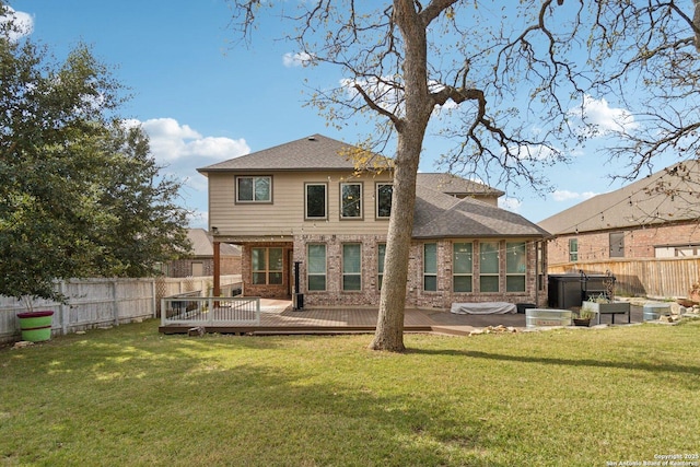 rear view of house with a deck and a yard