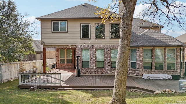 back of property with a lawn, a patio, and a wooden deck