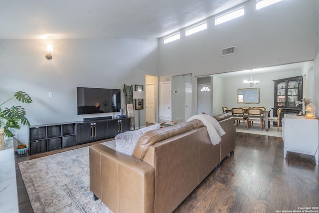 living room with a notable chandelier, dark hardwood / wood-style flooring, and a towering ceiling