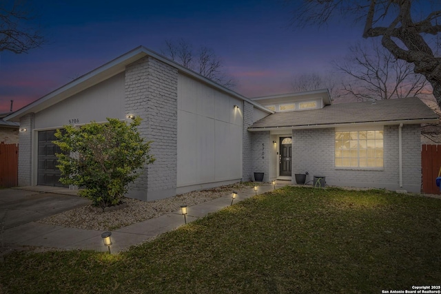 view of front of property with a garage and a yard