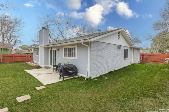 rear view of property with a lawn and a patio area