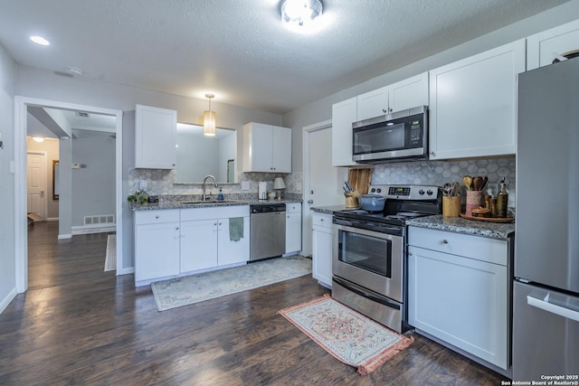 kitchen with white cabinetry, appliances with stainless steel finishes, decorative backsplash, decorative light fixtures, and sink