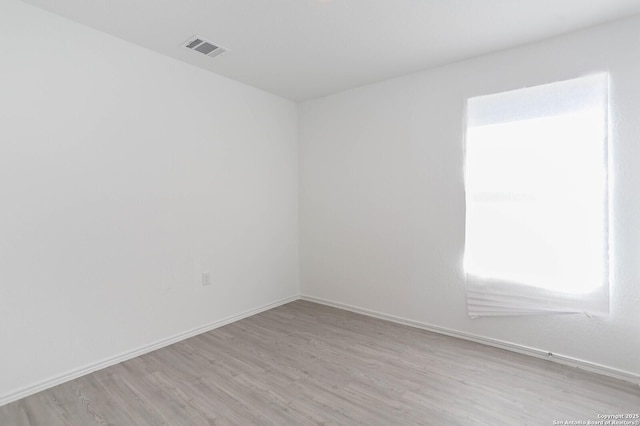 spare room with a healthy amount of sunlight and light hardwood / wood-style flooring