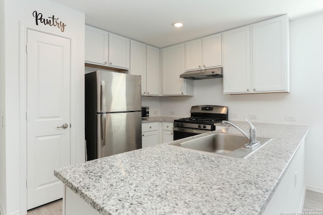 kitchen with sink, kitchen peninsula, white cabinets, and stainless steel appliances