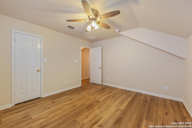 interior space with ceiling fan, lofted ceiling, and light wood-type flooring