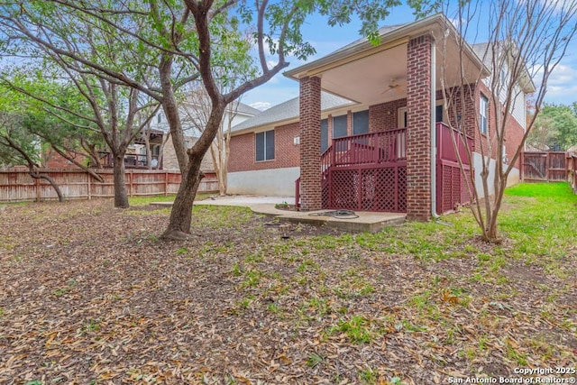 back of house featuring ceiling fan and a wooden deck