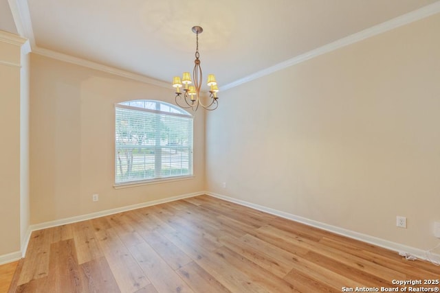 empty room featuring light hardwood / wood-style flooring, crown molding, and a chandelier