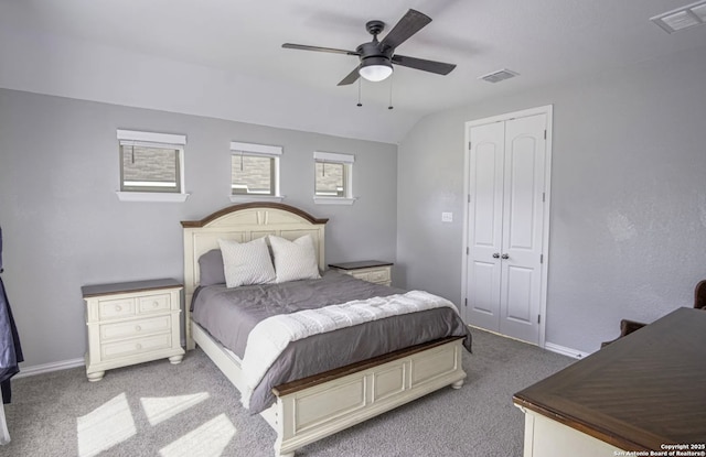 carpeted bedroom with vaulted ceiling, ceiling fan, and a closet