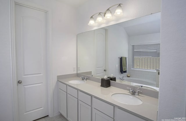 bathroom with a tub to relax in, vanity, and tile patterned flooring