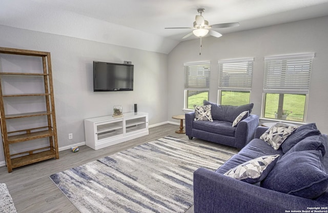 living room featuring light wood-type flooring, ceiling fan, a wealth of natural light, and lofted ceiling