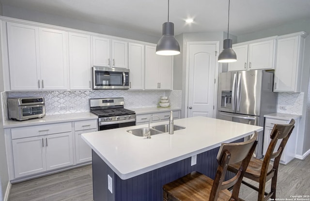 kitchen with appliances with stainless steel finishes, sink, and white cabinetry