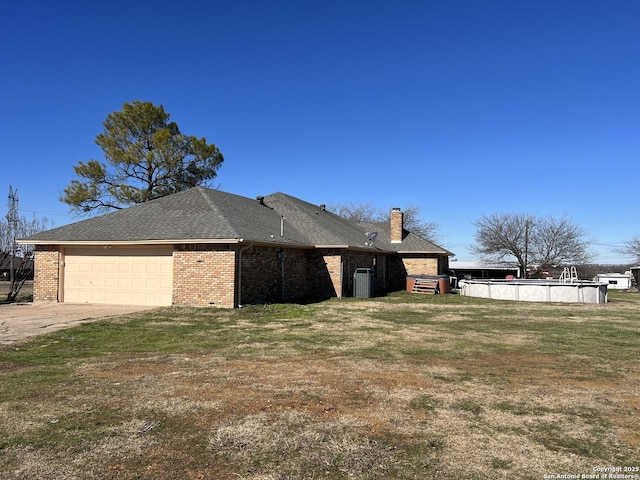 view of home's exterior featuring a lawn, central AC, and a garage