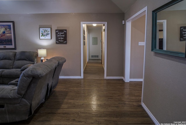 corridor featuring lofted ceiling and dark hardwood / wood-style floors