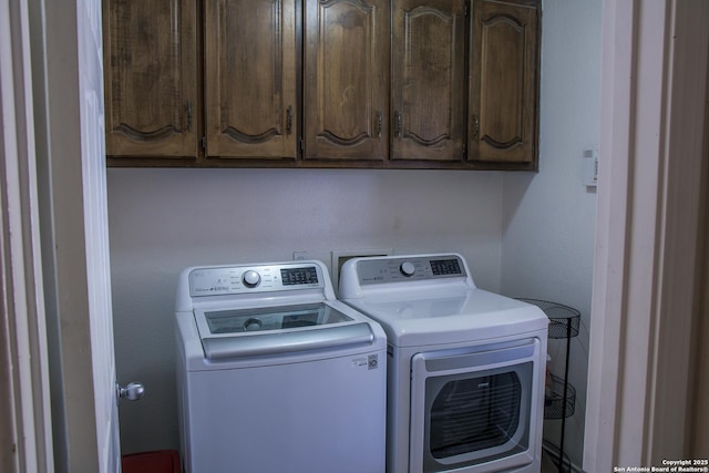 laundry area with cabinets and washing machine and clothes dryer