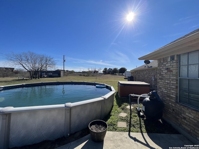 view of pool with a hot tub and a lawn