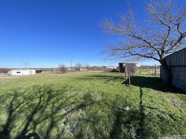 view of yard featuring a rural view and an outdoor structure