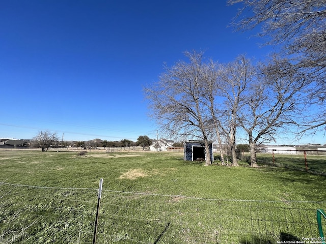 view of yard with a rural view and a storage unit