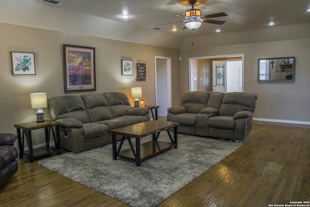 living room with ceiling fan and dark wood-type flooring