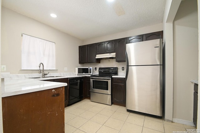 kitchen with dark brown cabinetry, sink, stainless steel appliances, and a textured ceiling