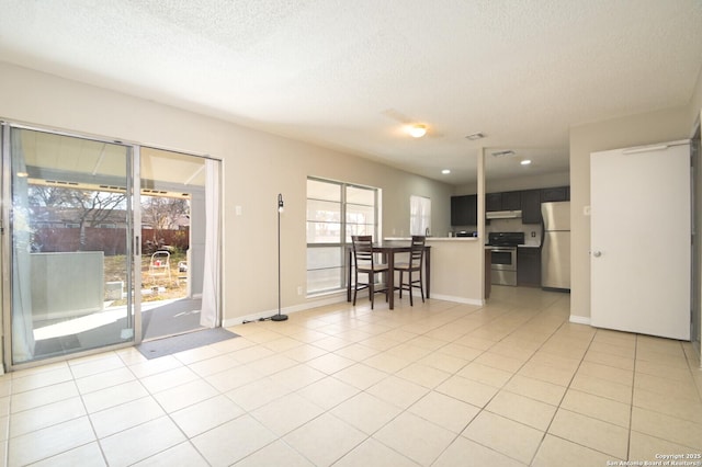 interior space with a textured ceiling and light tile patterned flooring