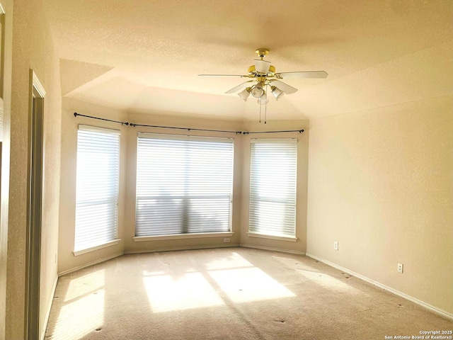 unfurnished room with lofted ceiling, ceiling fan, and a wealth of natural light